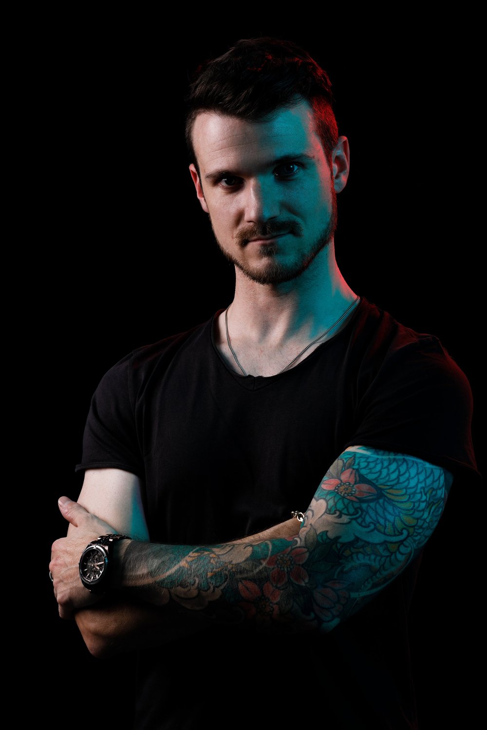 Jan, Leadgitarre, Arme verschränkt, farbiges Sleeve-Tattoo.